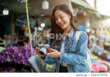 A beautiful Asian woman enjoys strolling through a flower market in Thailand. A beautiful Asian woman enjoys strolling through a flower market in Thailand. 120327478