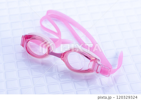 白いタイルの上に置かれたピンクの子供用水中眼鏡 白いタイルの上に置かれたピンクの子供用水中眼鏡 120329324