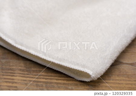 木のテーブルに置かれた白いフェイスタオル 120329335