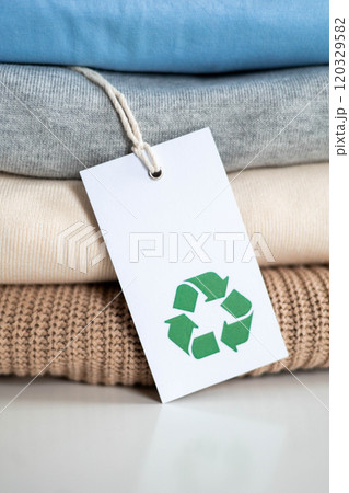 Stack of knitted clothes in neutral tones made of natural materials lies on table. Stack of knitted clothes in neutral tones made of natural materials lies on table. 120329582