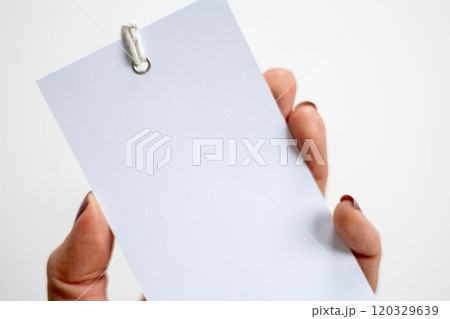 Hand holding blank white label on clean white background. 120329639