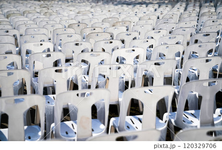 Many white plastic chairs were set up in a square area with the row and column for outdoor concerts or open air events. 120329706