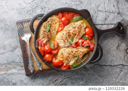 Chicken Pomodoro is an Italian dish made with tender breast smothered in fresh tomato sauce made with cherry tomatoes and fresh herb sclose up on the pan. Horizontal top view 120332226