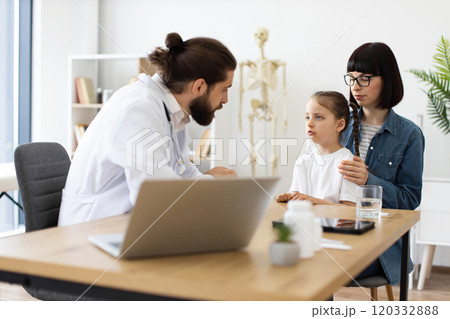 Doctor discusses health concerns with mother and young girl at clinic Doctor discusses health concerns with mother and young girl at clinic 120332888