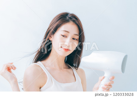ドライヤーで髪を乾かす女性 120333028