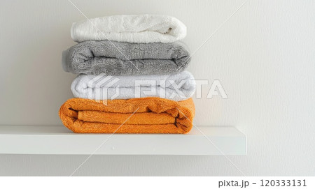 Clean towels neatly folded and stacked on a white shelf, ready for household use. Cleaning company. Copyspace 120333131