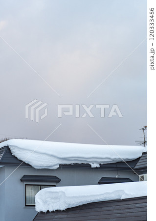 冬空の下、屋根に積もった雪 120333486