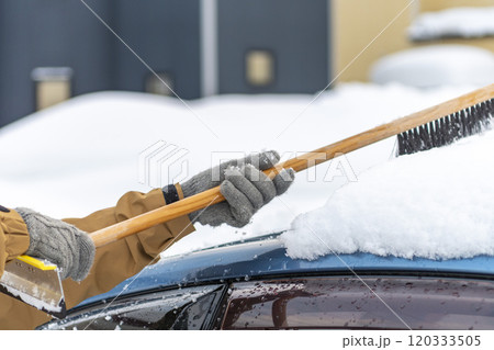 車に積もった雪をスノーブラシで下ろす 車に積もった雪をスノーブラシで下ろす 120333505