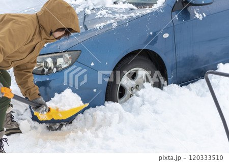 車の周りを雪かきする女性 車の周りを雪かきする女性 120333510