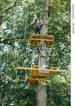 Embark on an exhilarating treetop adventure designed for outdoor enthusiasts in a beautiful, lush forest setting 120335091