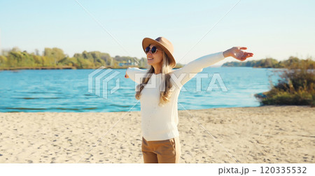 Happy smiling traveler woman on sunny beach, joyful girl enjoying on sea coast background 120335532