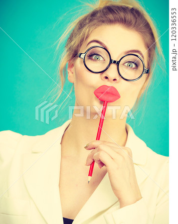 Happy woman holding fake lips on stick Happy woman holding fake lips on stick 120336553