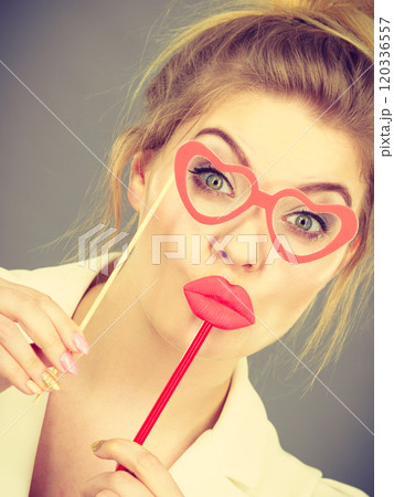 Happy elegant woman holding carnival accessoies on stick Happy elegant woman holding carnival accessoies on stick 120336557