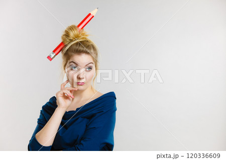 Thinking blonde woman having big pencil in hair Thinking blonde woman having big pencil in hair 120336609