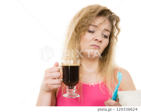 Tired woman holding toothbrush and coffee Tired woman holding toothbrush and coffee 120336624