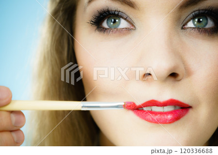 Applying lipstick on fashion model lips Applying lipstick on fashion model lips 120336688