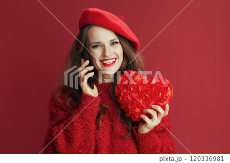 happy trendy woman in red sweater and beret talking on phone 120336981