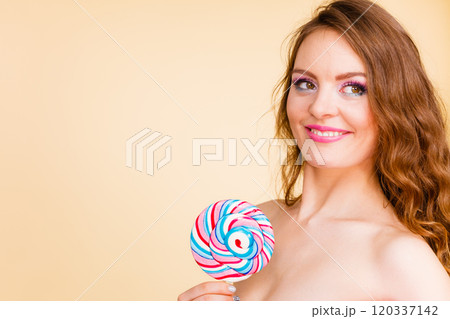 Woman holds colorful lollipop candy in hand Woman holds colorful lollipop candy in hand 120337142