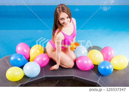 Girl relaxing at swimming pool with drink 120337347