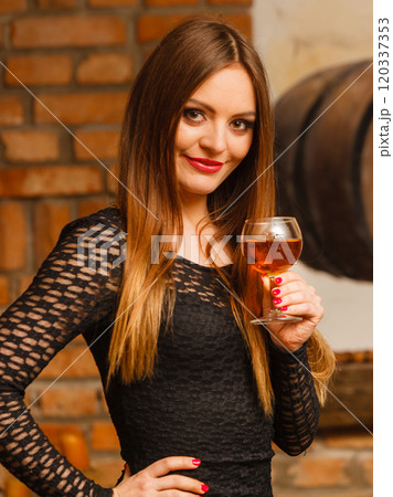 Woman tasting wine in rural cottage interior Woman tasting wine in rural cottage interior 120337353