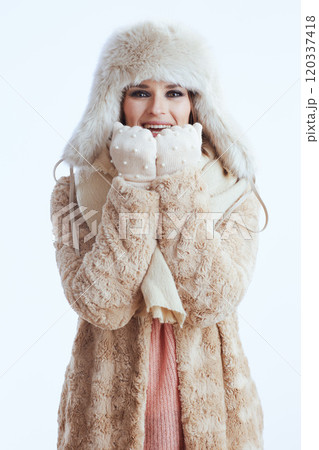 happy stylish woman warming hands with breath on white happy stylish woman warming hands with breath on white 120337418