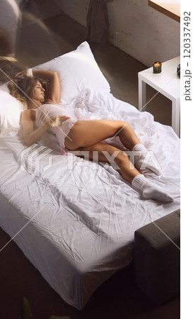 aerial view of woman wearing light pink sleepwear outfit and white socks, with natural light coming through window. aerial view of woman wearing light pink sleepwear outfit and white socks, with natural light coming through window. 120337492