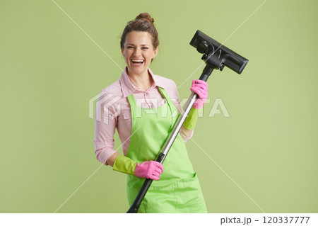 happy modern woman vacuum cleaner isolated on green 120337777