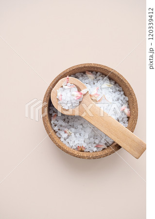 Aromatic bath salt with flower petals in wooden bowl, top view. Aromatic bath salt with flower petals in wooden bowl, top view. 120339412