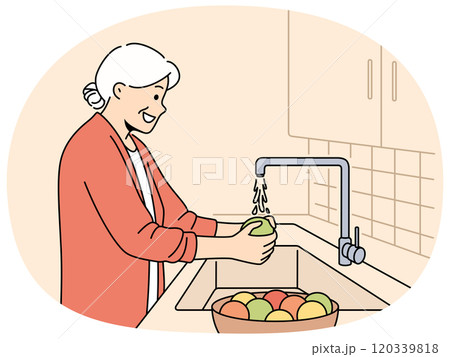Elderly woman washes fruits in sink, standing in kitchen and observing rules of hygiene 120339818