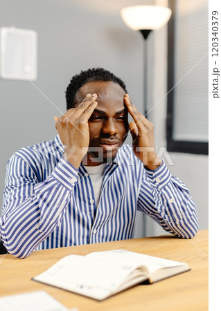 Businessman suffering from headache after working all day long in office Businessman suffering from headache after working all day long in office 120340379