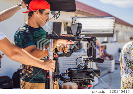 Steadicam operator prepare camera and 3-axis stabilizer-gimbal for a commercial shoot Steadicam operator prepare camera and 3-axis stabilizer-gimbal for a commercial shoot 120340416