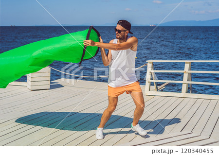 Man tries to inflate an air sofa. lamzac 120340455