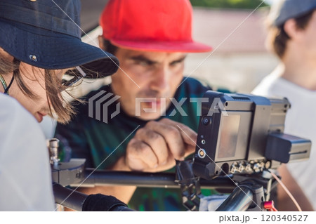 Steadicam operator and his assistant prepare camera and 3-axis stabilizer-gimbal for a commercial shoot 120340527