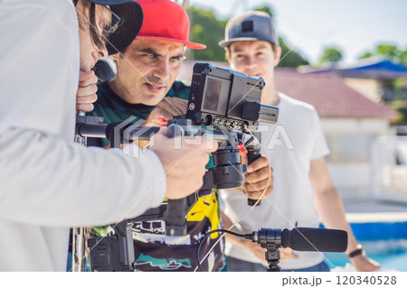 Steadicam operator and his assistant prepare camera and 3-axis stabilizer-gimbal for a commercial shoot 120340528