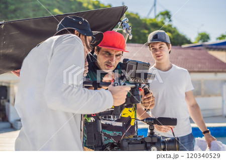 Steadicam operator and his assistant prepare camera and 3-axis stabilizer-gimbal for a commercial shoot Steadicam operator and his assistant prepare camera and 3-axis stabilizer-gimbal for a commercial shoot 120340529