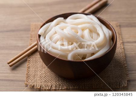 Udon noodles in wooden bowl with chopsticks, Thick noodles in Japanese cuisine Udon noodles in wooden bowl with chopsticks, Thick noodles in Japanese cuisine 120343845