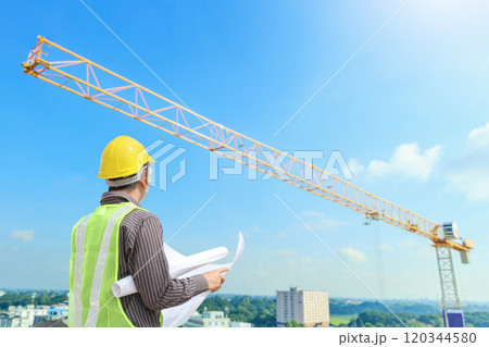construction engineer worker in protective helmet and blueprints paper on hand at building site background 120344580