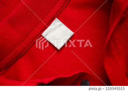 Blank white laundry care clothes label on red shirt fabric texture background 120345015