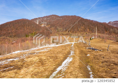 season change in carpathian mountains. seasonal transition. sunny day in spring. leafless forest and snow on the hill. nature landscape 120345852