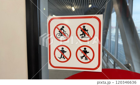 Sign on glass with symbols prohibiting use of personal transport for safety reason Sign on glass with symbols prohibiting use of personal transport for safety reason 120346636