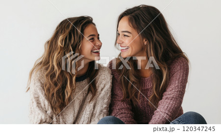Studio portrait of smiling mother and teenage daughter - family bonding concept 120347245