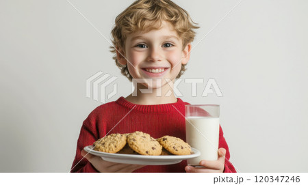 Joyful child with homemade cookies and milk for snack time 120347246