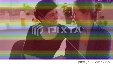 Image of pride rainbow stripes over happy caucasian lesbian couple using laptop at home Image of pride rainbow stripes over happy caucasian lesbian couple using laptop at home 120347799