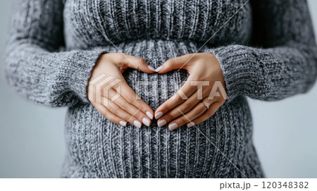 Close-up of pregnant woman's hands forming a heart on belly - maternity love Close-up of pregnant woman's hands forming a heart on belly - maternity love 120348382