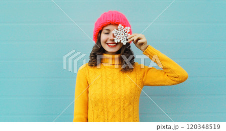 Winter christmas portrait of happy smiling woman with snowflakes toys having fun on blue background Winter christmas portrait of happy smiling woman with snowflakes toys having fun on blue background 120348519