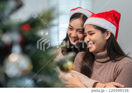 Young Couple Joyfully Decorating Their Room for Christmas Celebration with Festive Ornaments and Holiday Spirit 120349156