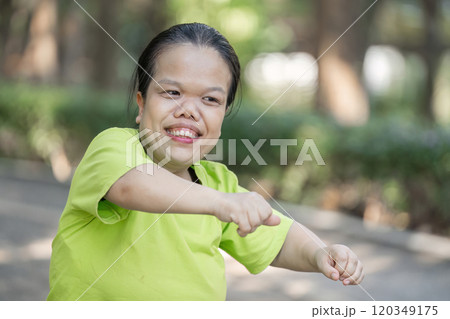 Young Disabled Woman Stretching Muscles Outdoors Before Exercise in a Park Setting for Fitness and Wellbeing 120349175
