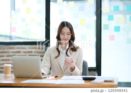 Businesswoman using a smartphone for communication, scheduling, and online business tasks. Businesswoman using a smartphone for communication, scheduling, and online business tasks. 120349341