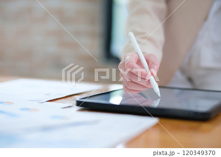 Close-up of hand signing electronic documents on a tablet with a digital pen for online workflows 120349370