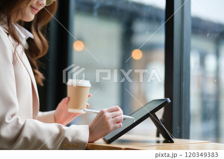 Close-up of a businesswoman using a tablet and stylus for work 120349383